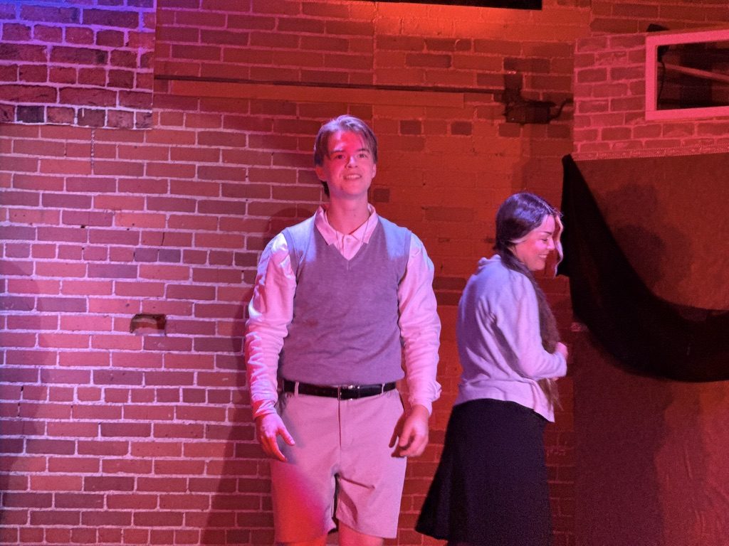 Teens lean against brick wall